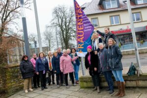 Franziska Matt (rechts) und Bürgermeister Otto Steinkamp (6. von links) zeigen gemeinsam mit Frauen aus Politik, Verwaltung, Vereinen und Verbänden Flagge zum Weltfrauentag. Foto: André Thöle / Gemeinde Wallenhorst