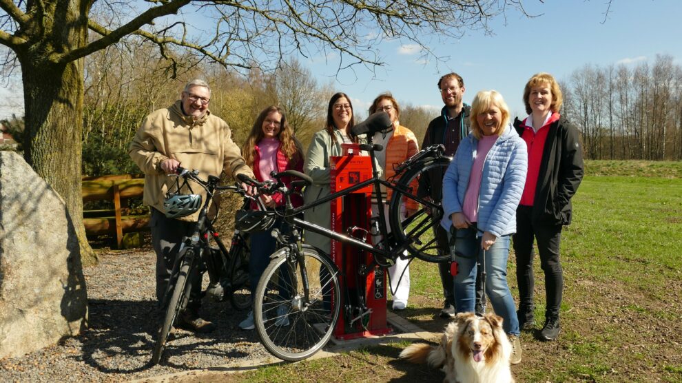 Präsentieren an der „Vehrter Meile“ in Belm die neuen Fahrrad-Reparatur- und Servicestationen in der VarusRegion im Osnabrücker Land, von rechts: Angelika Hoffstädt (Tourismusgesellschaft Osnabrücker Land), Anette Lange (Bohmte, mit Regions-Maskottchen Cooper), Stefan Brune (Wallenhorst), Christiane Wagner (Stadtmarketing Bramsche), Nadine Levermann (Tourist-Info Bad Essen), Maike Schlichting (Ostercappeln) und Dirk Meyer (Belm). Foto: VarusRegion im Osnabrücker Land