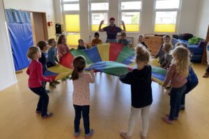 Welche Geräte verbrauchen viel Strom, welche weniger? Die Kinder des Kindergartens St. Stephanus zeigten die Lösung durch mehr oder weniger heftiges Schütteln des Energietuches. Foto: Gemeinde Wallenhorst