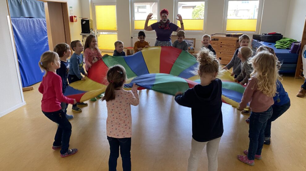 Welche Geräte verbrauchen viel Strom, welche weniger? Die Kinder des Kindergartens St. Stephanus zeigten die Lösung durch mehr oder weniger heftiges Schütteln des Energietuches. Foto: Gemeinde Wallenhorst