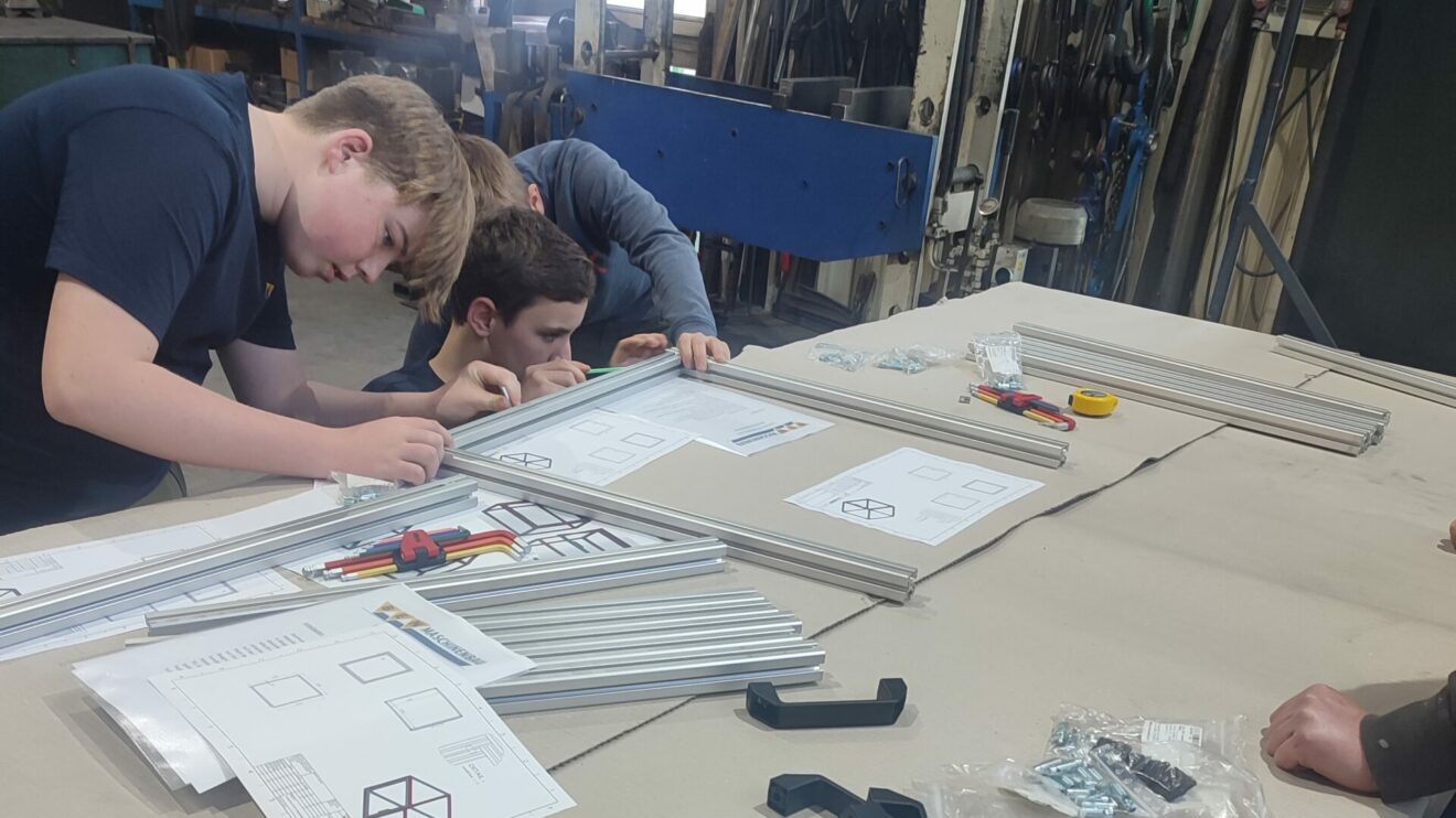 Vier Realschüler haben in einer GenerationenWerkstatt bei BEN-Maschinenbau in Wallenhorst Schutzgehäuse für die 3D-Drucker der Realschule Wallenhorst erstellt. Foto: Babette Rüscher-Ufermann