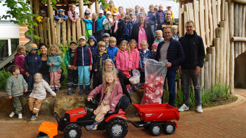 Freuen sich über den neuen Trettrecker mit Kehrmaschine und Mulde: Die Kindergarten-Kinder aus der Andreas-Kindertagesstätte in Hollage. Foto: Andreas-Kindertagesstätte / Mareike Teepe