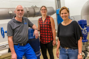 Markus Wächter (Wasserversorgung), Isabella Markfort und Martina Fänger (von links) vor den Pumpen im Wasserwerk, die in den Spitzenabnahmezeiten bis zu 350 Kubikmeter Wasser pro Stunde fördern. Foto: André Thöle / Gemeinde Wallenhorst