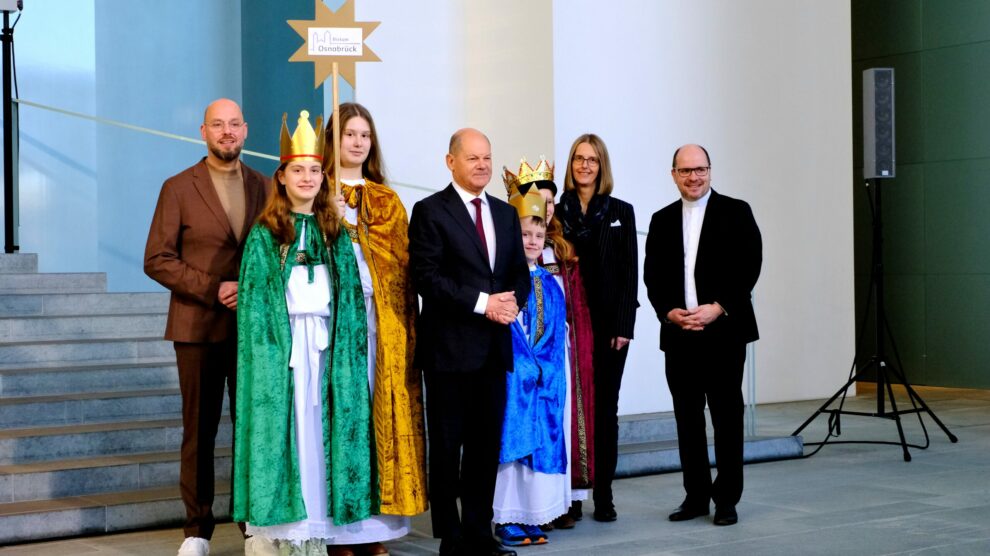 Die Sternsinger Anna (15), Marie (12), Ben (9) und Johanna Maria (12) sowie Begleiterin Doreen Dopheide aus der Gemeinde St. Josef in Wallenhorst-Hollage vertraten das Bistum Osnabrück am Montagnachmittag beim Sternsinger-Empfang von Bundeskanzler Olaf Scholz zur 66. Aktion Dreikönigssingen. Zum Gruppenfoto mit dem Kanzler stellten sie sich gemeinsam mit Pfarrer Dirk Bingener, Präsident des Kindermissionswerks ‚Die Sternsinger‘, und Domvikar Stefan Ottersbach, Bundespräses des Bundes der Deutschen Katholischen Jugend (BDKJ), im Bundeskanzleramt auf. Foto: Ralf Adloff/ Kindermissionswerk