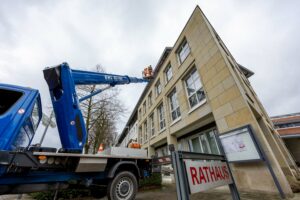 Unter dem Dach des Rathauses wird der neue Nistkasten für Mauersegler montiert. Foto: André Thöle