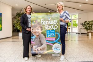 Sandra Holzmann und Christina Middendorp mit dem Osnabrücker Ferienspaß-Plakat. Foto: Gemeinde Wallenhorst / André Thöle