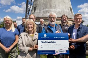 Heike Knöpke überreicht einen symbolischen Fördervertrag über 75.000 Euro an Franz-Josef Albers (Windmühle Lechtingen e.V.) und Bürgermeister Otto Steinkamp. Foto: Gemeinde Wallenhorst