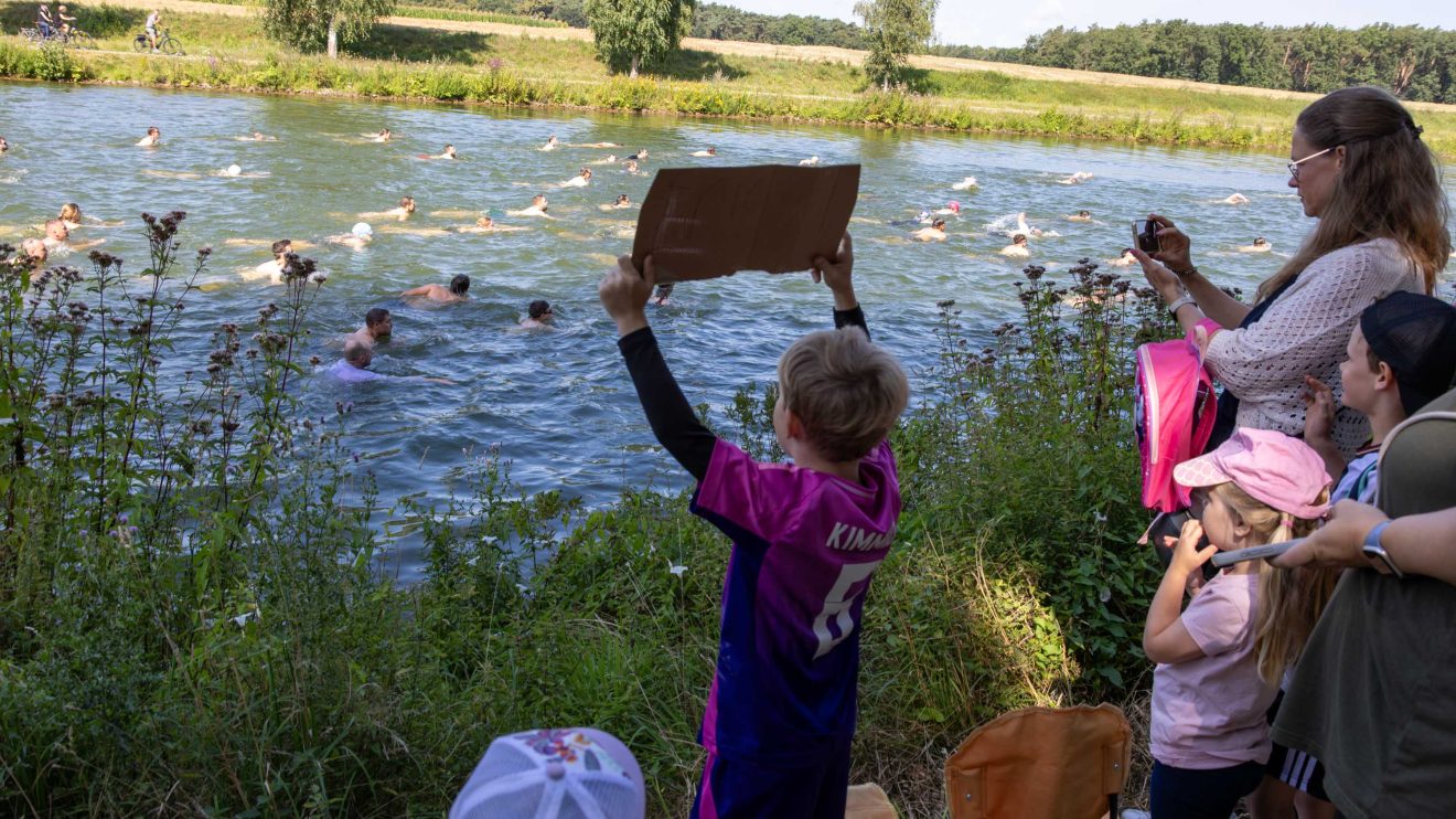 Vom Ufer aus feuern die Fans die Schwimmerinnen und Schwimmer an.