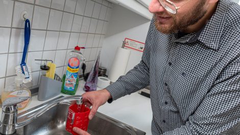 Stefan Brune demonstriert die Funktionsweise eines Durchflussmengen-Messbechers. Foto: Thomas Remme / Gemeinde Wallenhorst