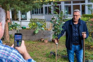 Bürgermeister Otto Steinkamp pflanzt im Rahmen der Social-Media-Challenge einen Apfelbaum im Schulgarten der Alexanderschule. Foto: Gemeinde Wallenhorst / André Thöle