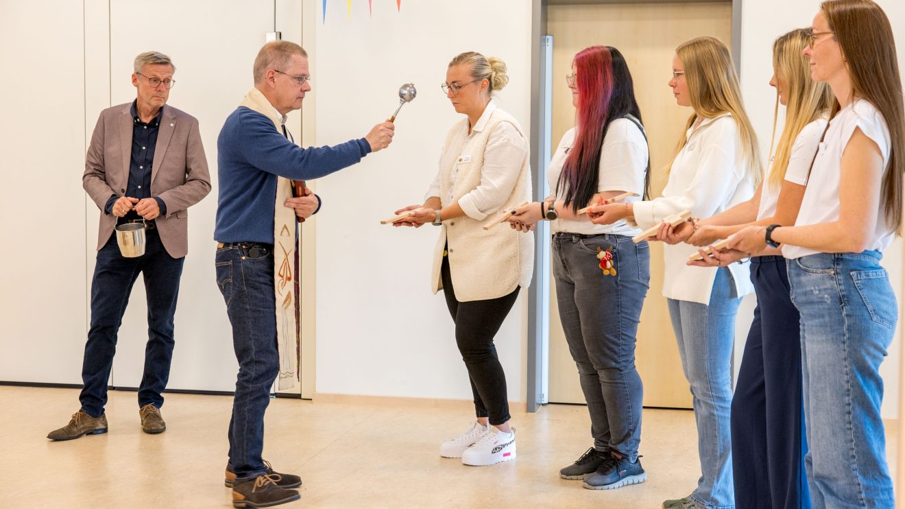 Pfarrer Bernhard Horstmann segnet die Kreuze für die Gruppenräume. Foto: André Thöle / Gemeinde Wallenhorst