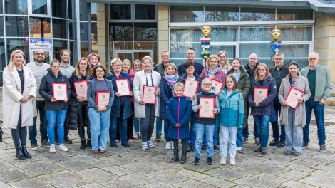 Gemeinsam mit Bürgermeister Otto Steinkamp (3. von rechts) und Stefan Brune (4. von links) präsentieren die ausgezeichneten Einrichtungen ihre Urkunden. Foto: André Thöle / Gemeinde Wallenhorst