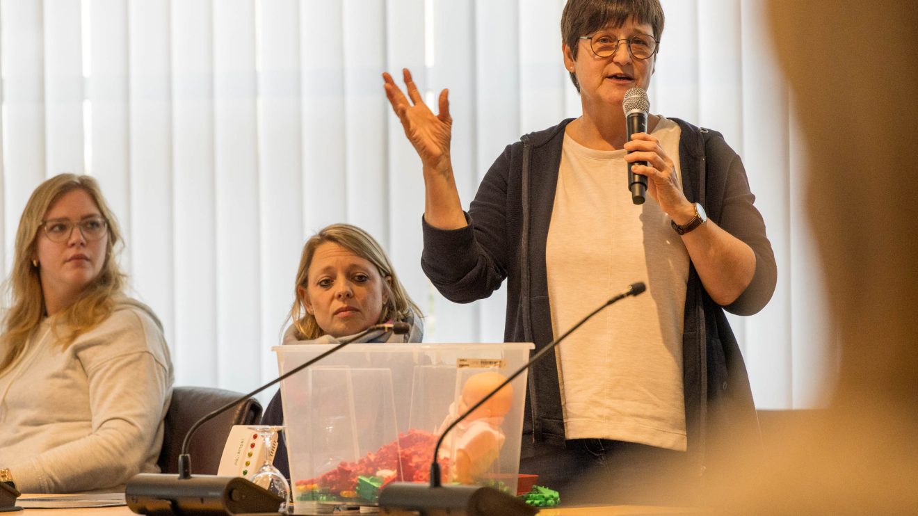 Karin Albers stellt die Materialkiste des Kindergartens St. Raphael vor. Foto: André Thöle / Gemeinde Wallenhorst