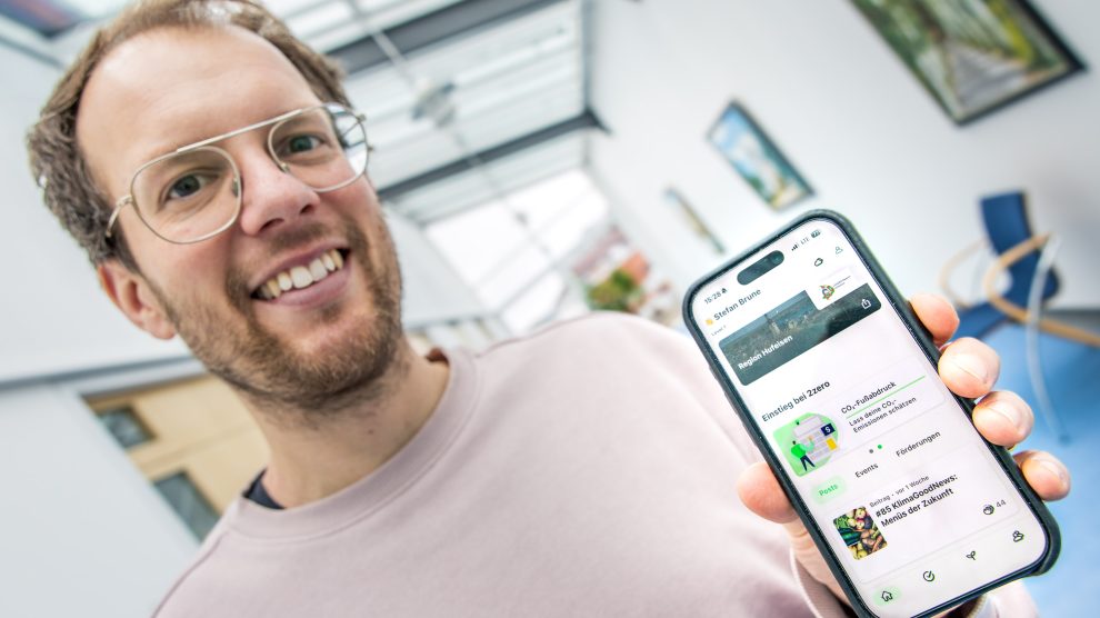 Wallenhorsts Klimaschutzmanager Stefan Brune zeigt die Klimathon-App. Foto: André Thöle / Gemeinde Wallenhorst