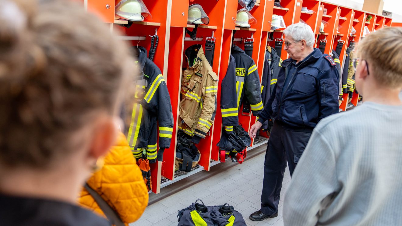 Manfred de Vries zeigt die Ausrüstung der Freiwilligen Feuerwehr. Foto: Gemeinde Wallenhorst / André Thöle