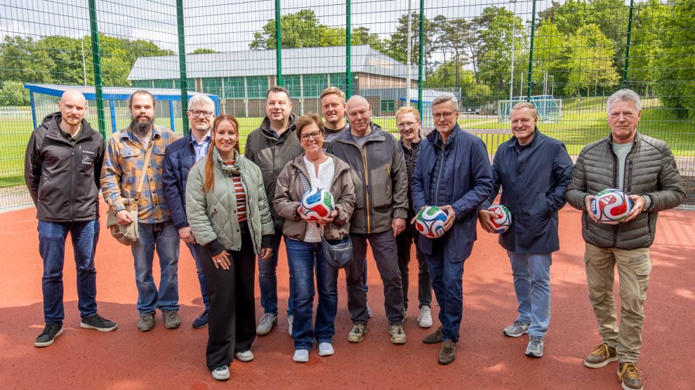 Gemeinsam mit Ratsmitgliedern, am Bau beteiligten Unternehmen und Förderern gibt Bürgermeister Otto Steinkamp (3. von rechts) den Bolzplatz an der Uhlandstraße frei. Foto: Gemeinde Wallenhorst / André Thöle